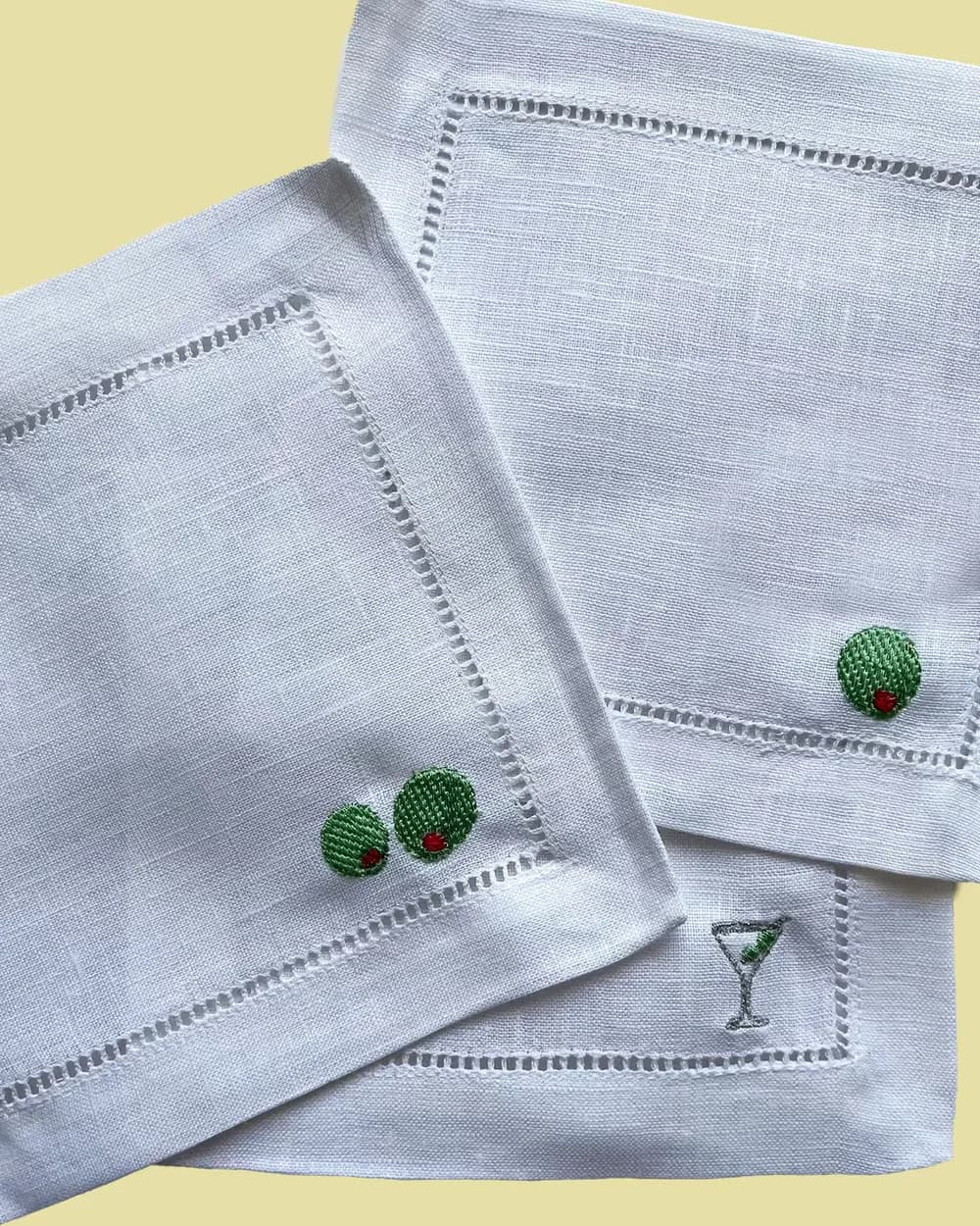 Close-up detail of an embroidered cherry icon on a napkin